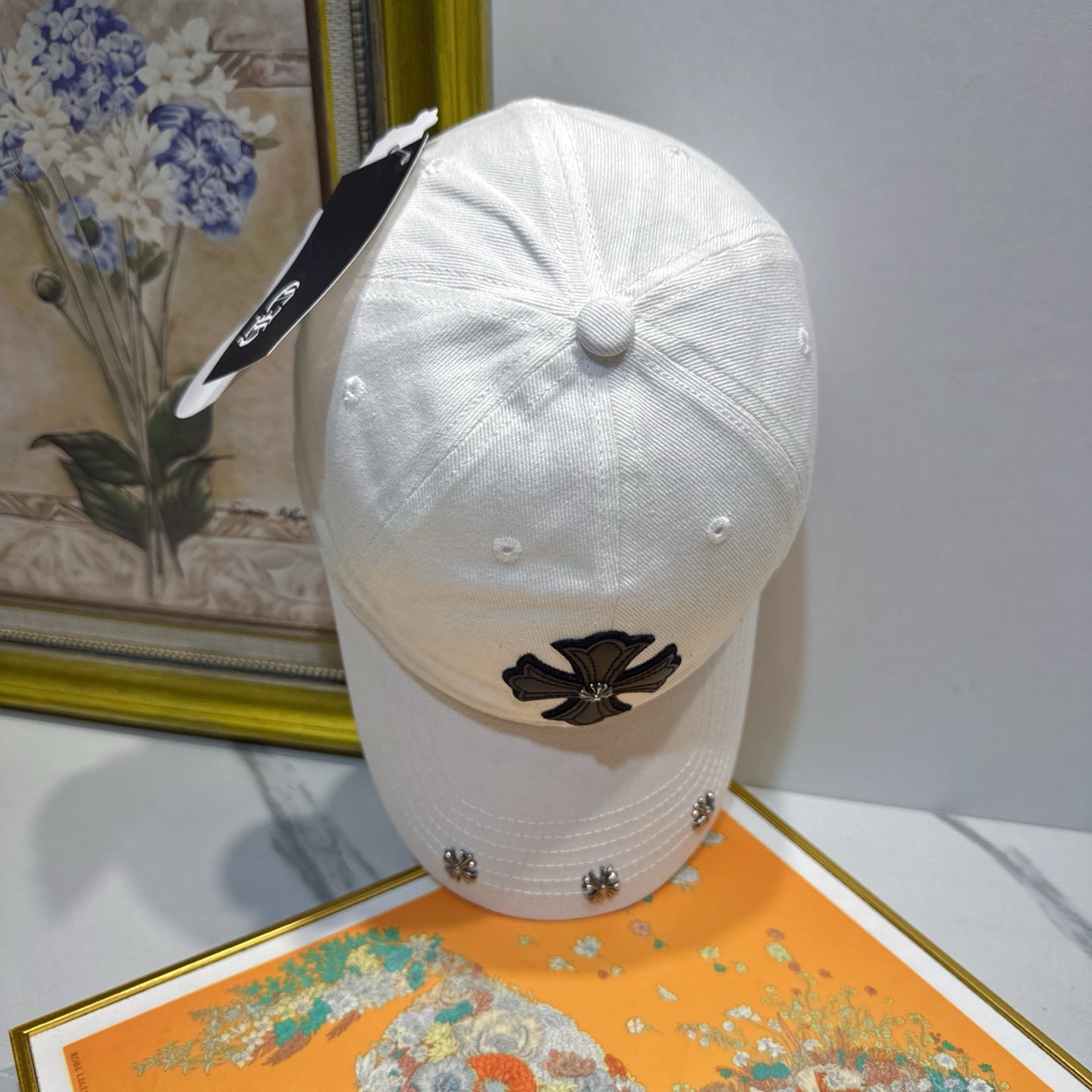 A white washed and distressed baseball cap from Chrome Hearts.