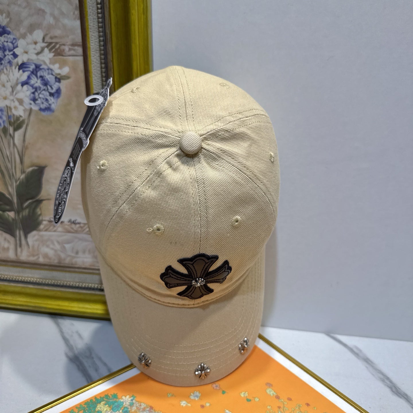 A cream-colored baseball cap by Chrome Hearts.